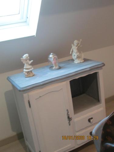 a toy cabinet with three figurines on top of it at studios les Hortensias in Lillers