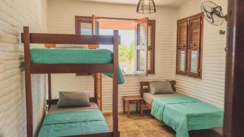 two bunk beds in a room with a window at Lineup Kite & Surf House in Taíba