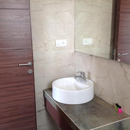 a bathroom with a sink and a mirror at Pals Hotel in Mumbai
