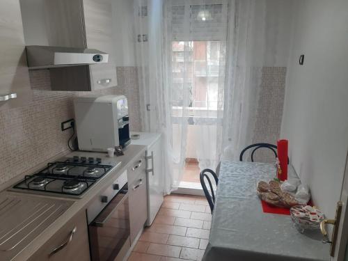 a kitchen with a stove and a counter with a table at Sleep&Go airlines pisa in Pisa