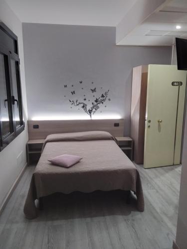 1 dormitorio con 1 cama y un árbol con pájaros en la pared en Hotel Alle Scuole NEW, en Curtarolo