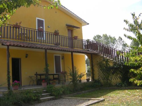a yellow house with a balcony and a table at Etruria Life in Sutri
