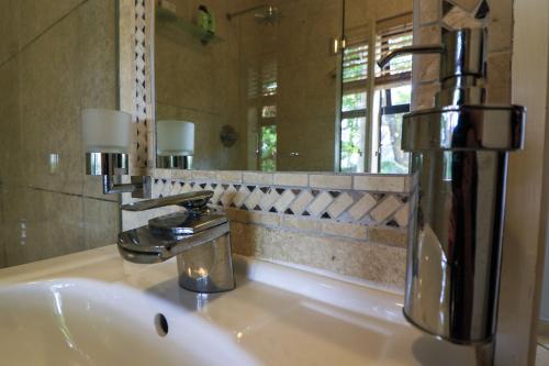 La salle de bains est pourvue d'un lavabo, d'un robinet et d'un miroir. dans l'établissement @93 Accommodation, à Mtunzini