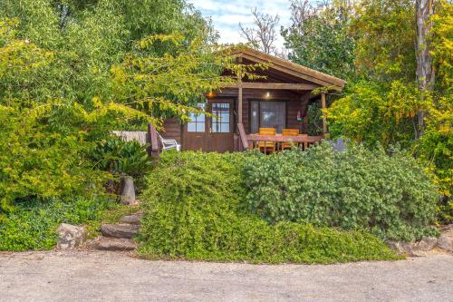 a small cabin with a table in front of it at Nof Kinneret Cabins in Had Nes