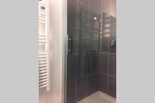 La salle de bains est pourvue d'une douche avec une porte en verre. dans l'établissement clos des mûriers, à Beaune