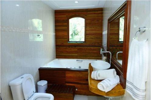 a bathroom with a tub and a toilet and a sink at Pousada Lua e Sol in Estancia do Castello