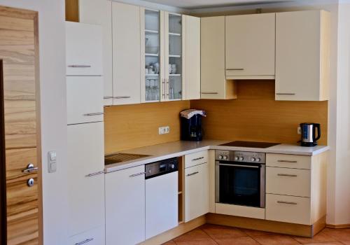 a kitchen with white cabinets and a stove at Appartementhaus Riepler in Bad Gastein