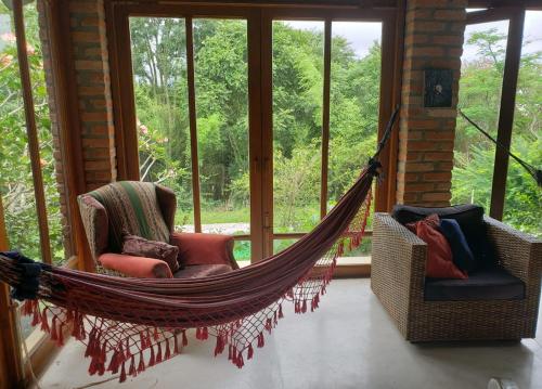a hammock in a room with windows at Toca da Capuava in Cotia