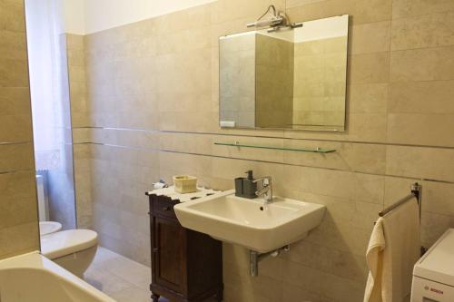 a bathroom with a sink and a mirror and a toilet at B&B Casa a colori in Verona