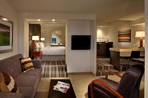 a living room with a couch and a bedroom at Cambridge Suites Hotel Halifax in Halifax
