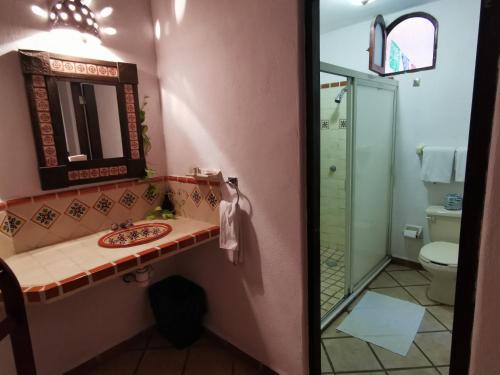 a bathroom with a sink and a mirror and a toilet at Villas Vista Suites Sayulita in Sayulita