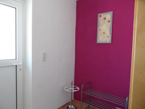 una habitación con una pared púrpura con una pintura en Appartement Reiter, en Aschau