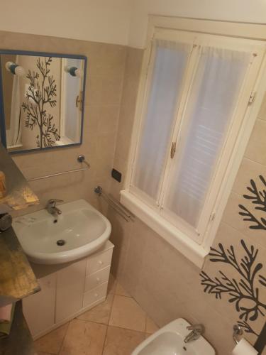 een badkamer met een wastafel, een toilet en een raam bij Philips apartment in Milaan