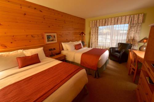 una habitación de hotel con 2 camas y una silla en Hôtel Le Francis, en New Richmond