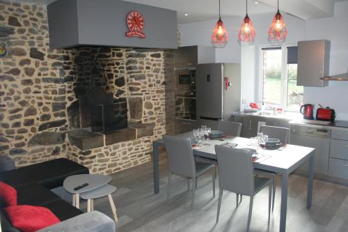une cuisine avec une table et des chaises ainsi qu'une cheminée dans l'établissement A 20 kms du Mont St Michel, Charme à la campagne, à Saint-Senier-de-Beuvron