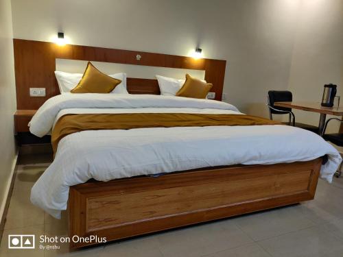 Schlafzimmer mit einem großen Bett mit einem Kopfteil aus Holz in der Unterkunft Hotel HV in Nahan