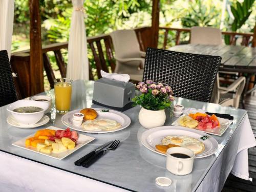 a table with plates of breakfast food on it at Hotel Madreselva in Leticia