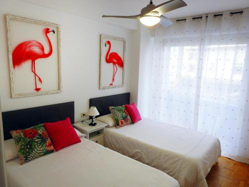 オウレンセにあるApartamento Ourense Existe Casco Histórico Parking opcionalのベッド2台 赤い鳥が壁に浮かぶ部屋