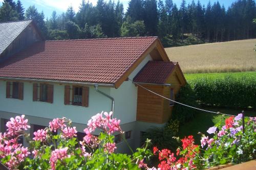 a house with a red roof and some flowers at Appartement Steiner in Breitenbrunn