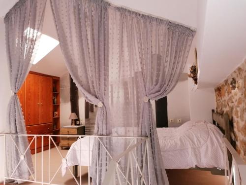 a bedroom with a bed and a curtain at THEOS APARTMENTS in Kalymnos