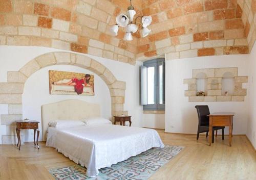 a bedroom with a white bed and a brick wall at Don Pedro di Toledo in Monopoli