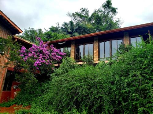 a house with trees and purple flowers in front of it at Toca da Capuava in Cotia