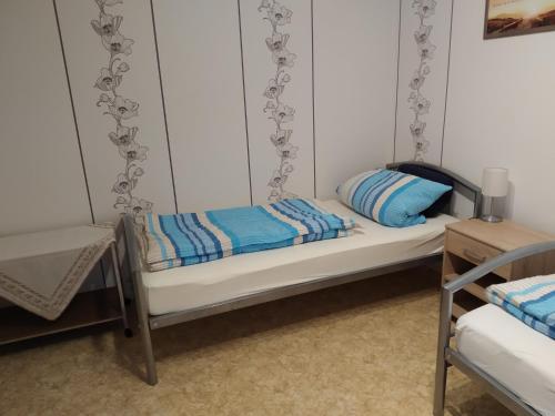a small bed with blue pillows on it at FeWo Schwalbennest in Patersberg