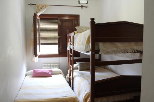 two bunk beds in a room with a window at Apartamento Rurales Rosendo: La Zajareña in Capileira