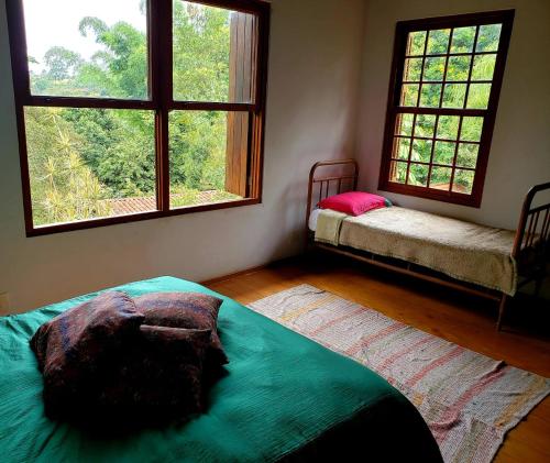 a room with two beds and two windows in it at Toca da Capuava in Cotia