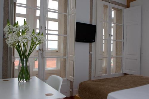 un dormitorio con un jarrón de flores sobre una mesa en el Hotel Pazo de Altamira de Santiago de Compostela