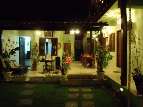 a house with a patio at night with potted plants at Pousada Horizonte dos Borbas in Abraão