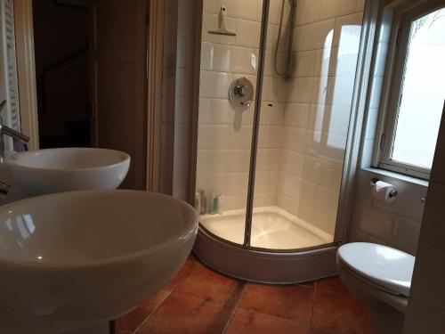 La salle de bains est pourvue de 2 lavabos et d'une douche. dans l'établissement Bed & Bye Schiphol, à Badhoevedorp
