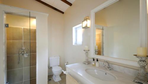 a bathroom with a sink and a toilet and a mirror at Anelina Paxos Residences (Elinas House) in Gaios