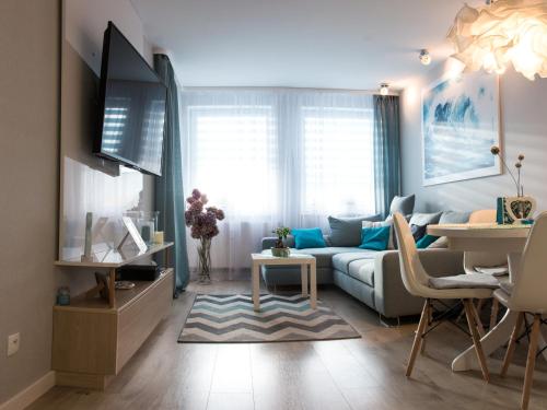 salon z kanapą i stołem w obiekcie Apartament FALA-Miodowy Dom w Kołobrzegu