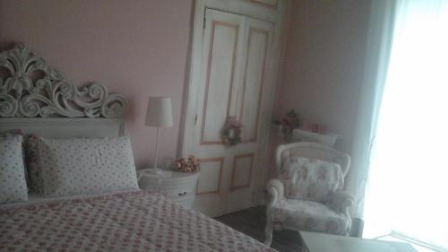 a bedroom with a white bed and a chair at Villa Di Miscio in SantʼAgata di Puglia