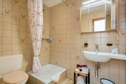 y baño con aseo y lavamanos. en Hotel Garni Bären Rüegsau, en Ruegsau