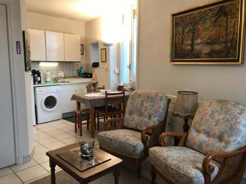 un salon avec deux chaises et une table dans l'établissement L'étape, Appartement près voie verte, randonnées, à Pouilly-sous-Charlieu