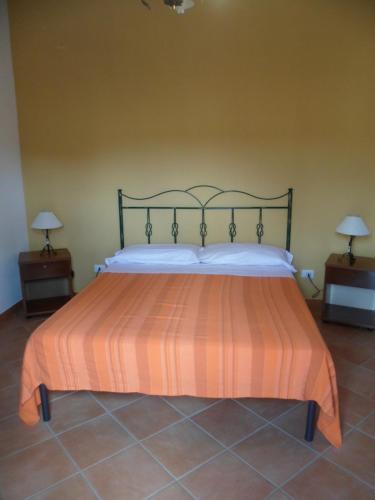 um quarto com uma cama com uma colcha laranja e branca em Acqua Marina em Custonaci