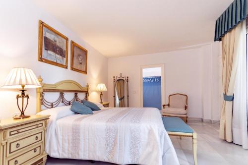 1 dormitorio con 1 cama, vestidor y silla en Castillo San Luis, en Torremolinos