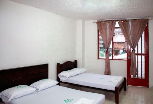 1 dormitorio con 2 camas y ventana en Hotel Farallones Cali, en Cali