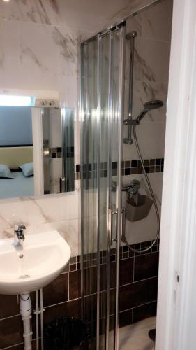 a bathroom with a shower and a sink at Hotel Les Arcades in Rouen