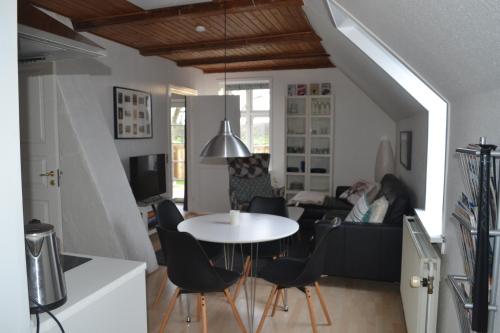 een woonkamer met een tafel en een persoon op een bank bij AD Apartment in Køge