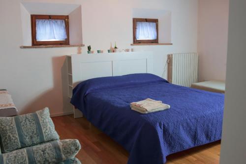 una camera da letto con un letto blu e una sedia di il mulino a SantʼArcangelo di Romagna