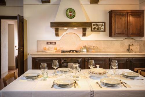 a kitchen with a table with plates and wine glasses at Agriturismo Cerreto in Pienza