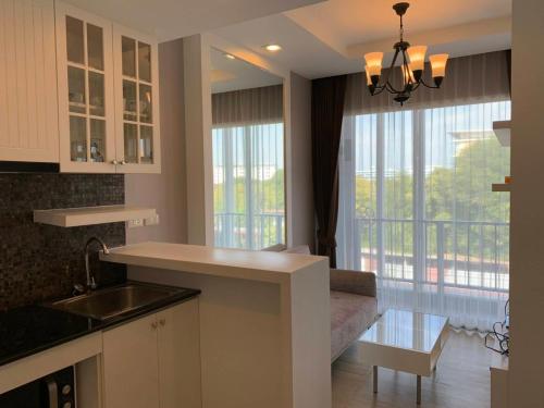 a kitchen with a sink and a large window at Cozy near beach 200m with toproof pool at Patio Bangsaen in Bangsaen
