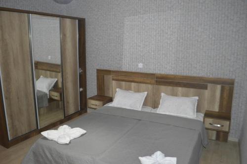 a bedroom with a large bed with a large mirror at hill-fort kutaisi in Kutaisi