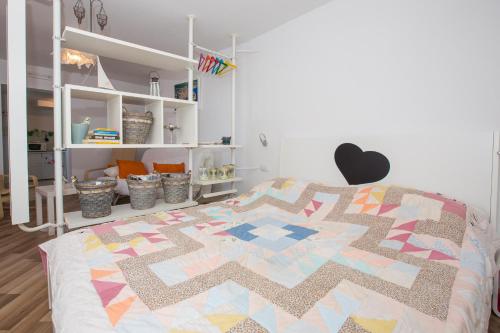 a bedroom with a bed with a colorful quilt on it at A bright hideaway in Dubrovnik