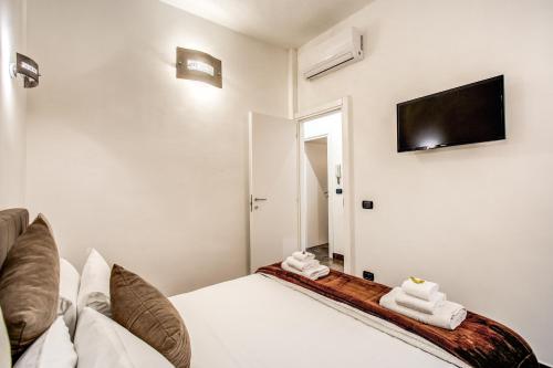 Laura luxury apartment in the center Rome في روما: غرفة نوم بسرير وتلفزيون بشاشة مسطحة