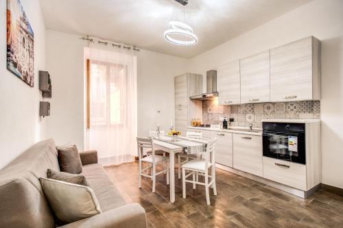 Laura luxury apartment in the center Rome في روما: غرفة معيشة مع أريكة وطاولة في مطبخ