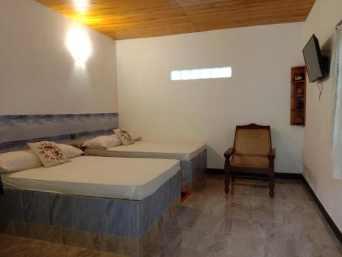 HaldummullaにあるThe Misty Mountain Guest Houseのベッド2台と椅子が備わる客室です。